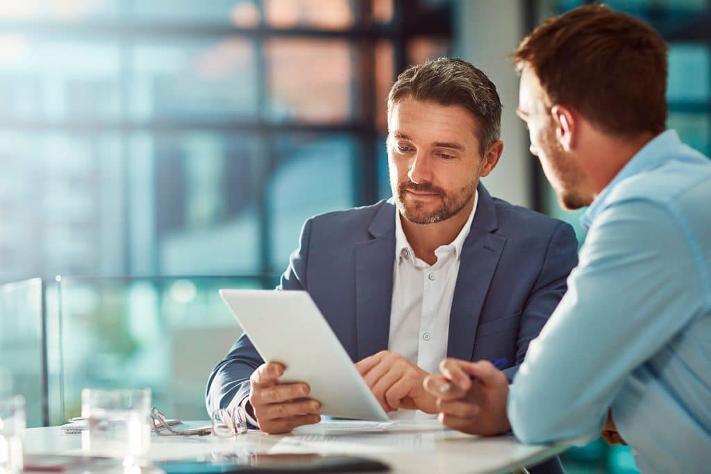 Two men pointing at tablet